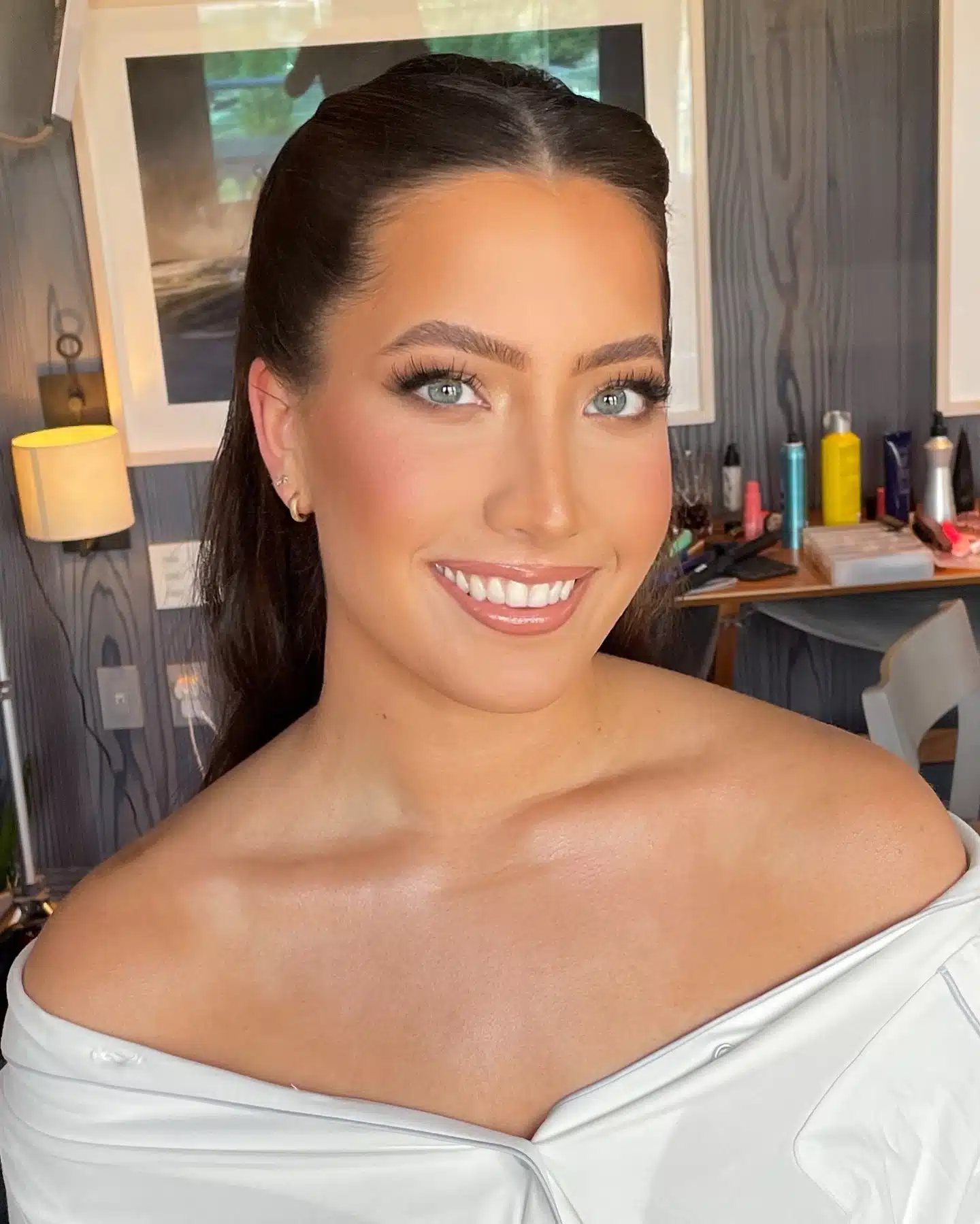 Bride smiling in her getting-ready suite after hair and makeup