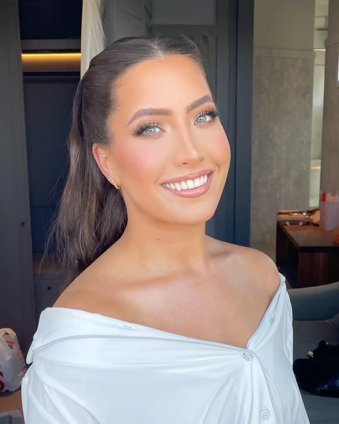 Finished bridal look with a sleek half-up style and soft glam makeup