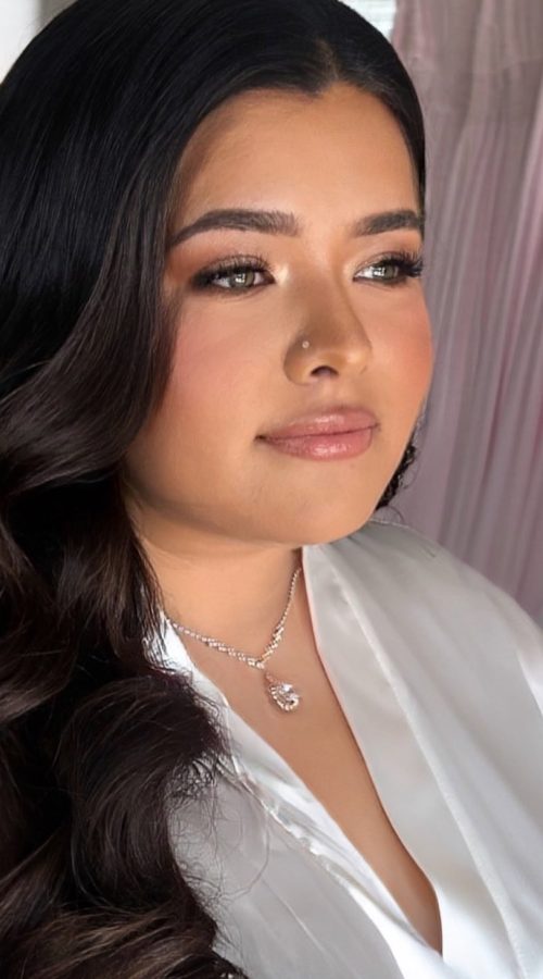 Bride in a robe with soft brunette waves and fluttery lashes